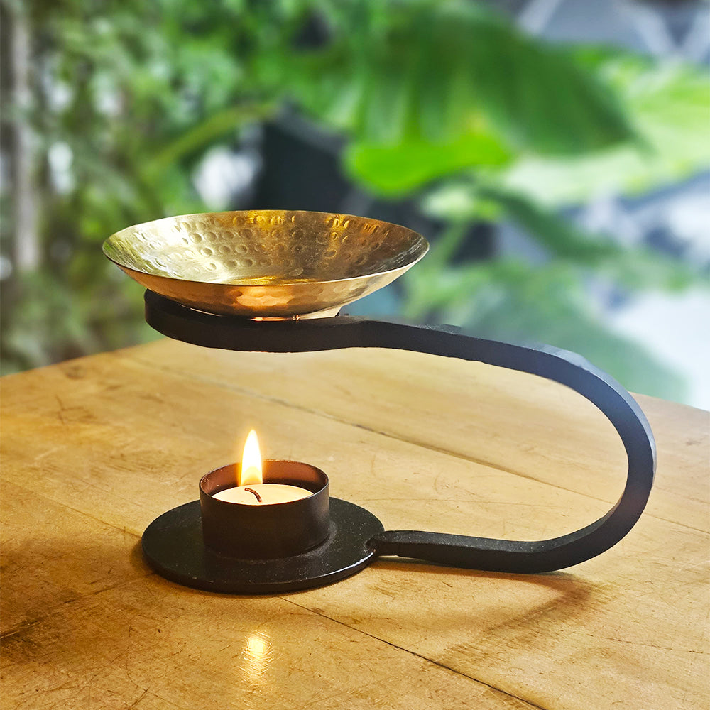 "Aadya oil burner crafted from cast iron with a hand-hammered brass bowl, featuring a sculptural design ideal for aromatherapy and artisanal home decor by Yellow Marigold."