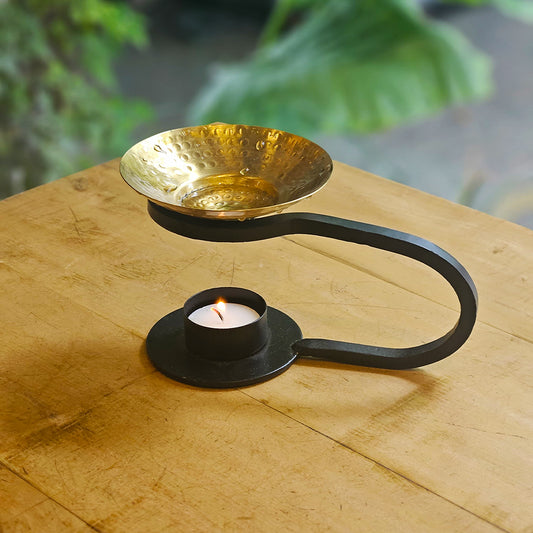 "Aadya oil burner crafted from cast iron with a hand-hammered brass bowl, featuring a sculptural design ideal for aromatherapy and artisanal home decor by Yellow Marigold."