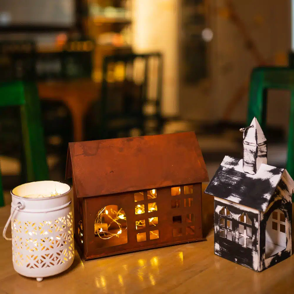 Yellow Marigold black metal hanging birdhouse lantern suspended from porch beam with warm candlelight — charming rustic décor for balcony or garden