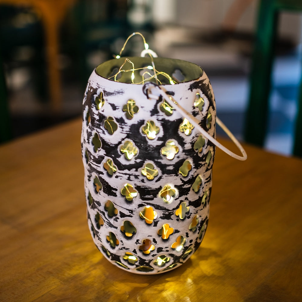 Yellow Marigold distressed metal hanging lantern — rustic metal lantern with glass panels hanging against plain background