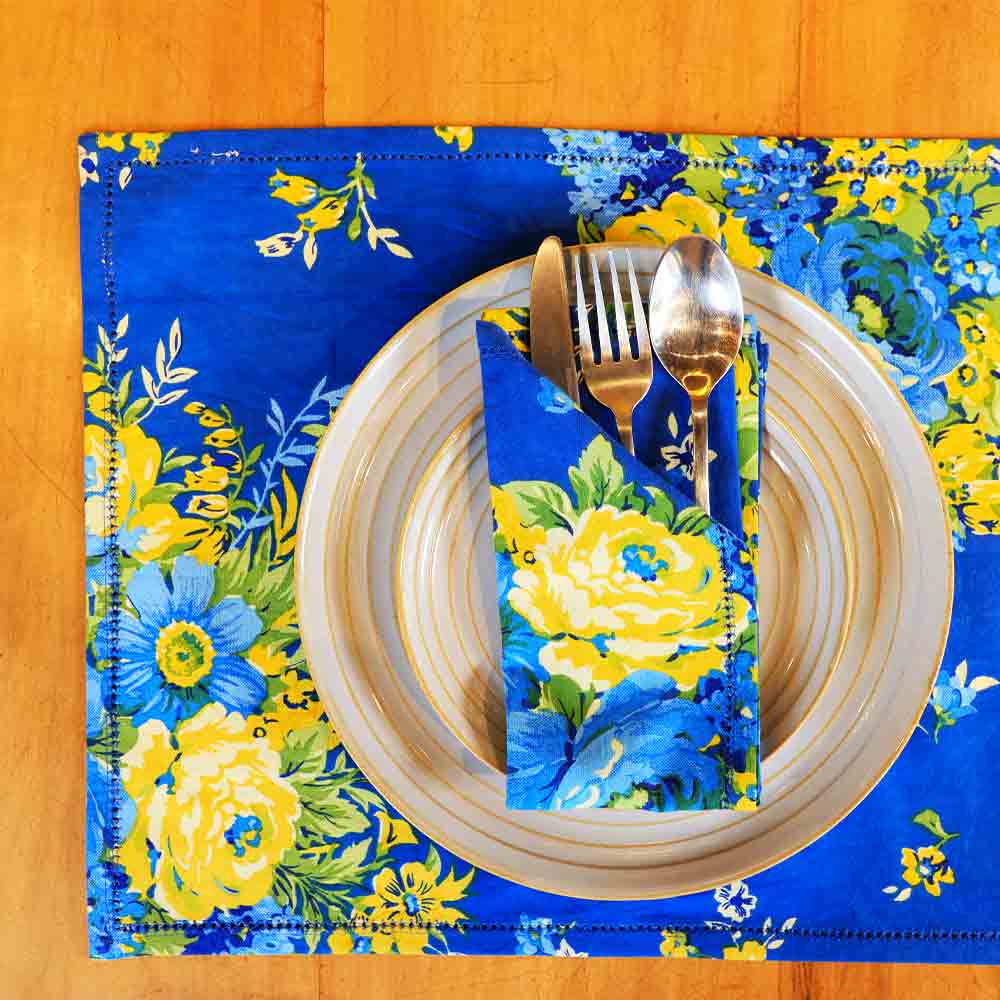 Yellow Marigold Avonlea Blue napkins (set of 6) placed beside crockery on a wooden dining table — elegant table setting