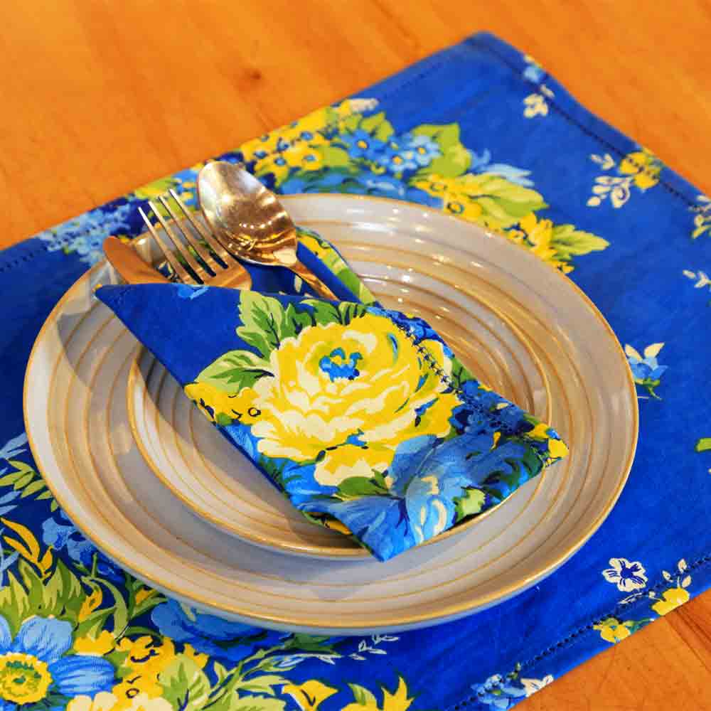 Yellow Marigold Avonlea Blue Placemats (set of 6) on a wooden dining table with crockery — elegant home dining ambience