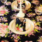 Yellow Marigold Blanche Black Floral Napkins (set of 6) placed beside crockery on a wood dining table — sophisticated table setting