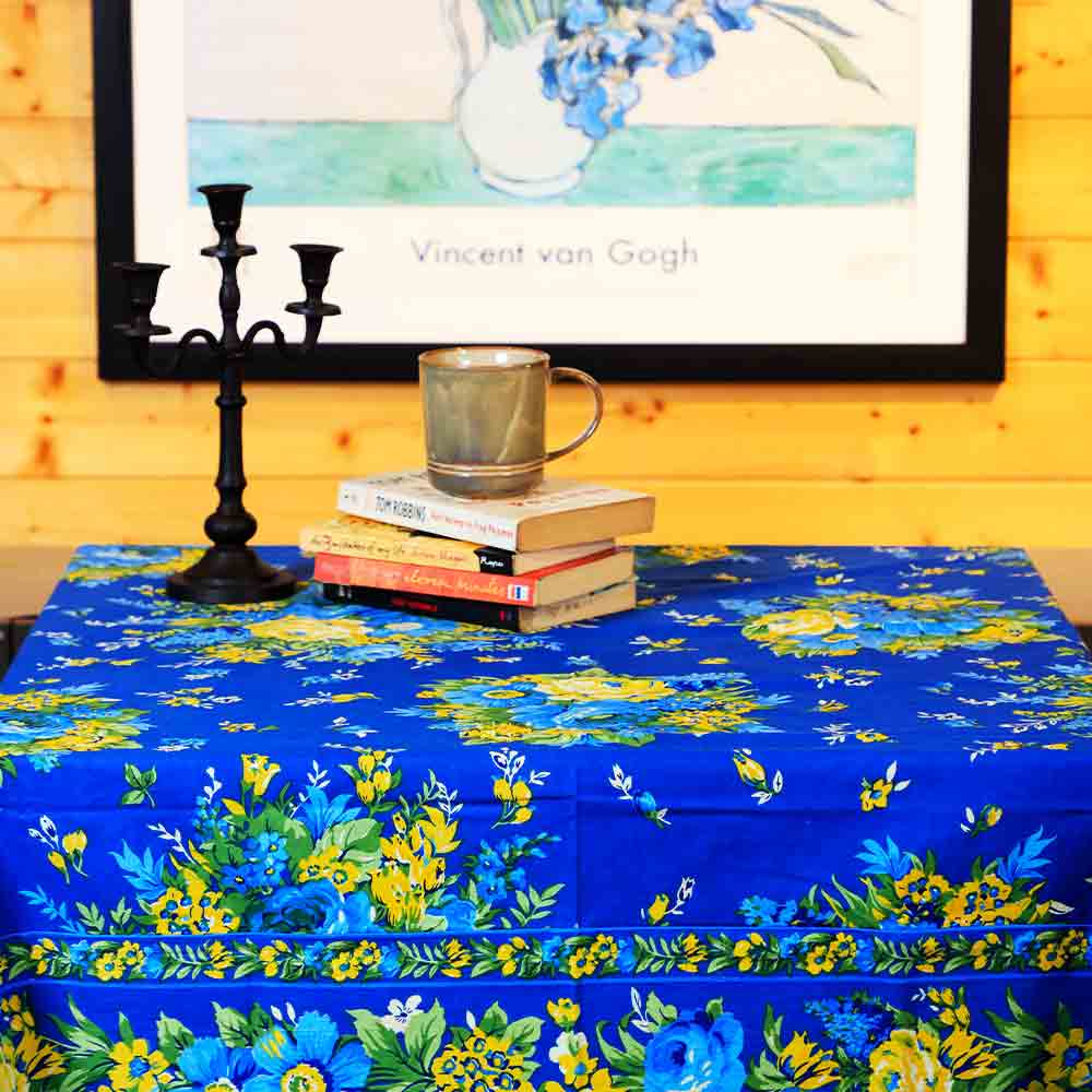 Yellow Marigold Avonlea Blue table cover covering wood dining table with crockery and décor — elegant home dining ambience