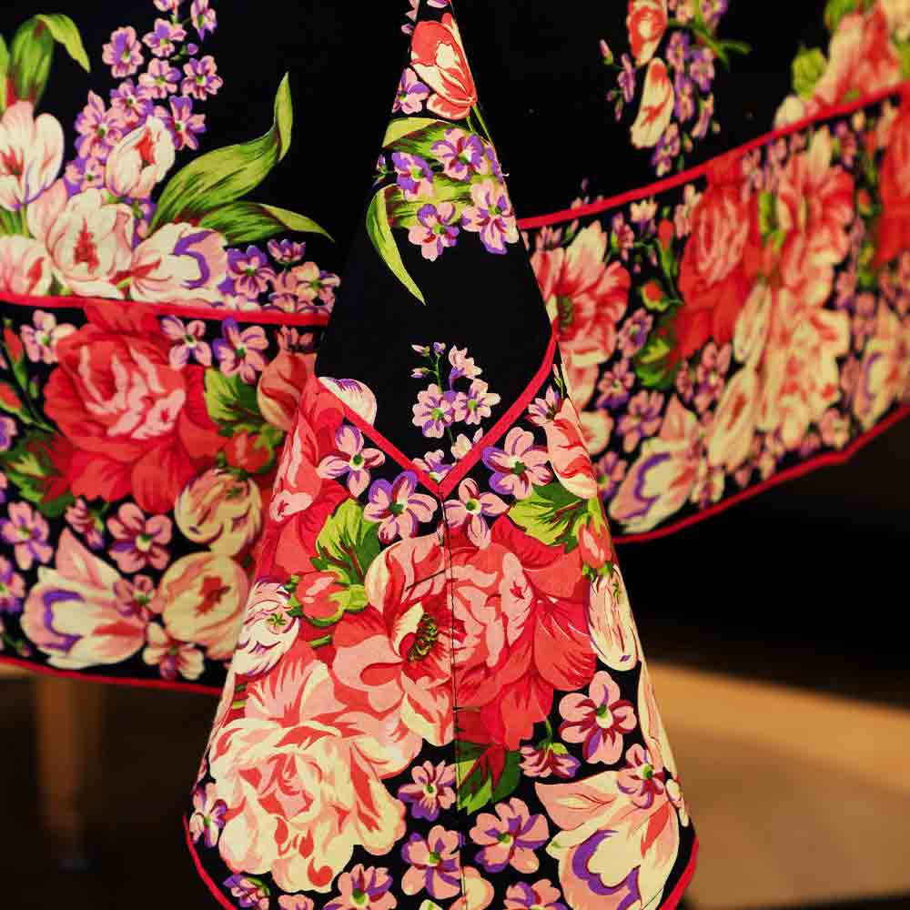 Yellow Marigold Blanche Black Floral tablecloth draped on a wooden dining table with crockery and décor — elegant modern dining ambience